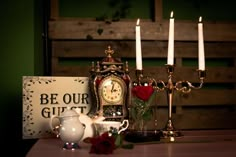 a table topped with candles and a clock