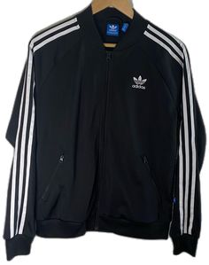 Fitted Black Track Jacket With Ribbed Cuffs, Black Long Sleeve Track Jacket For Spring, Adidas Black Track Jacket For Winter, Adidas Black Track Jacket For Spring, Black Track Jacket For Streetwear In Spring, Black Track Jacket For Spring Streetwear, Sporty Black Outerwear For Spring, Casual Black Track Jacket For Fall, Spring Adidas Black Track Jacket