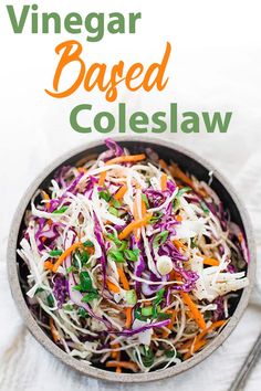 a bowl filled with coleslaw and carrots on top of a white table