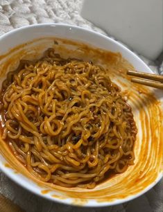 a white bowl filled with noodles and sauce