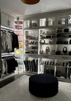 a closet with lots of shoes and handbags on the shelves in front of it