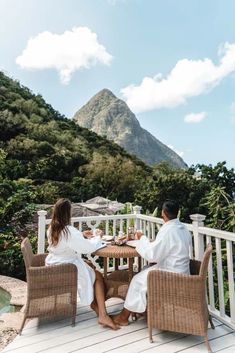 two people sitting at a table on a deck