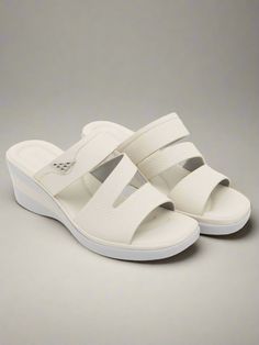 Upgrade your summer wardrobe with Siketu's Rica Cushioned Wedge Slides in Cream. These stylish and comfortable slides provide cushioned support with a trendy wedge design, making them the perfect addition to any outfit. Elevate your fashion and your comfort with these must-have slides. 2.36'' heel Slip-on PU upper Synthetic Arch support footbed™ Cushioned Insole™ Anti-skid rubber sole White Comfortable Sandals With Ortholite Insole, Comfortable White Sandals With Ortholite Insole, Summer Synthetic Wedge Sandals With Ortholite Insole, Comfortable Synthetic Wedge Sandals With Cushioned Footbed, Comfortable Wedge Sandals With Ortholite Insole, Comfortable Synthetic Wedge Sandals With Arch Support, Summer Wedge Sandals With Ortholite Insole, Modern Wedge Sandals With Arch Support For Summer, White Wedge Sandals With Arch Support