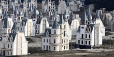 a large group of white buildings with towers and spires in the middle of nowhere