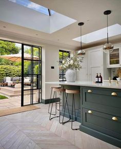 a kitchen with two stools in front of an open door that leads to a patio