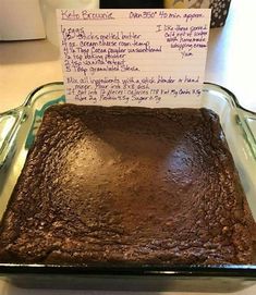 a chocolate cake sitting on top of a pan covered in frosting and writing notes