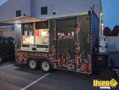 a food truck parked in a parking lot with lights on it's sides and the door open