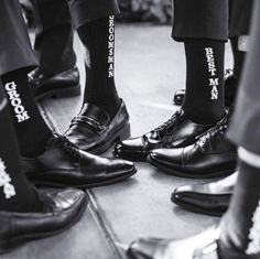 black and white photograph of men's feet wearing socks with words written on them