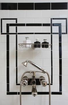 a black and white tiled bathroom with chrome faucet