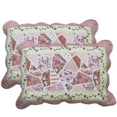 two pink and white quilted pillows sitting on top of each other