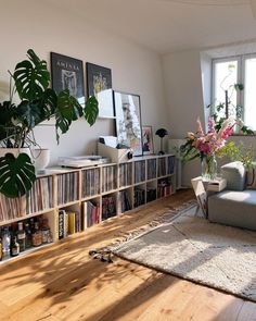 a living room filled with lots of furniture and bookshelves next to a window