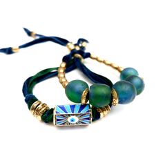 Handcrafted unique and super stylish bracelet made with two shades of french silk ribbon in blue and green, a gorgeous detailed enamel tubular center piece with a tiny evil eye, vintage African brass rings and danglers. Wear it alone or stacked with other bracelets. Bracelet is adjustable Made with love in Los Angeles Complimentary gift wrapping provided All sales final. Blue Wearable Art Jewelry For Festival, Adjustable Blue Jewelry In Wearable Art Style, Adjustable Blue Bracelets In Wearable Art Style, Evil Eye Vintage, Brass Rings, French Silk, Stylish Bracelet, Green A, Brass Ring