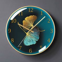 a blue and gold clock with a leaf on it