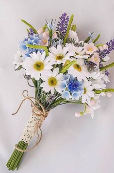 a bouquet of white and blue flowers tied to a string