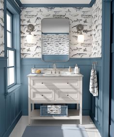 a bathroom with blue and white wallpaper, two sinks and a mirror on the wall