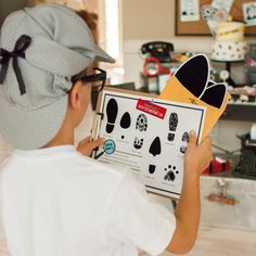 a young boy holding up a cut out of an animal's paw and foot