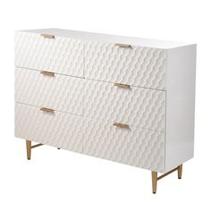 a white dresser with three drawers and gold handles on the bottom, in front of a white background