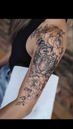 a woman with a tiger and flowers tattoo on her arm