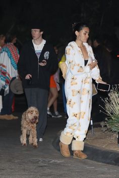 the woman is walking her dog down the street with other people in the back ground