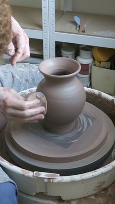 a person making a vase on a potter's wheel