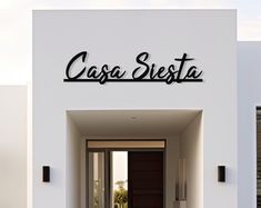 an entrance to a white building with black lettering