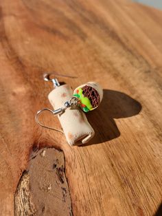 a wooden table with a pair of earrings hanging from it's earwires