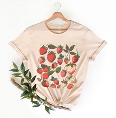 🍓Strawberry Graphic T-Shirt🍓 This classic unisex jersey short sleeve tee fits like a well-loved favorite. Soft cotton and quality print make users fall in love with it over and over again. These t-shirts have-ribbed knit collars to bolster shaping. The shoulders have taping for better fit over time. Dual side seams hold the garment's shape for longer. -100% Airlume combed and ringspun cotton (fiber content may vary for different colors) -Light fabric (4.2 oz/yd² (142 g/m - Retail fit - Tear aw Making Graphic Tees, Strawberry Fashion, Strawberry Tops, Strawberry Clothes, Strawberry Tshirt, Strawberry Clothing, Strawberry Graphic, Shirt Outfit Ideas, Quilt Size Chart