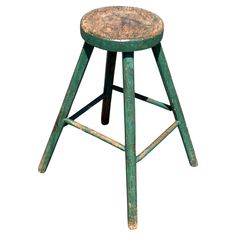 an old green stool with a wooden seat