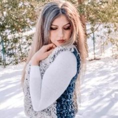 a woman with long hair standing in the snow