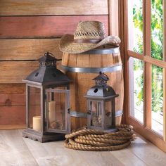 two lanterns and a hat on top of a barrel