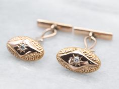 These cufflinks, circa the late 1800s, are the very definition of sophistication. The warm antique gold radiates with a warm and inviting luster. The cufflinks are decorated with a curling, curving scalloped motif, giving the old mine-cut diamonds the perfect backdrop to sparkle. What a wonderful wedding gift these will make!Metal: 10K Antique Rose Gold, 14K Yellow Gold Gem: 2 Old Mine Cut Diamonds totaling .12 Carats, VS in Clarity, G-H in ColorGem Measurements: 2.2 mm, RoundMeasurements: 18 x 10 mm Antique Yellow Gold Formal Cufflinks, Antique Yellow Gold Cufflinks For Formal Occasions, Luxury Antique Finish Jewelry For Formal Occasions, Antique Gold Cufflinks, Antique Hallmarked Cufflinks For Wedding, Hallmarked Antique Cufflinks For Wedding, Vintage Yellow Gold Cufflinks With Polished Finish, Antique Gold Cufflinks For Collectors, Antique Polished Cufflinks For Anniversary