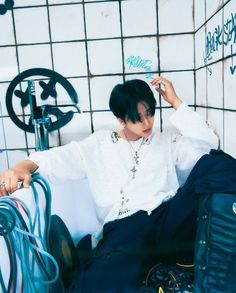 a man sitting on top of a white couch next to a wall covered in graffiti