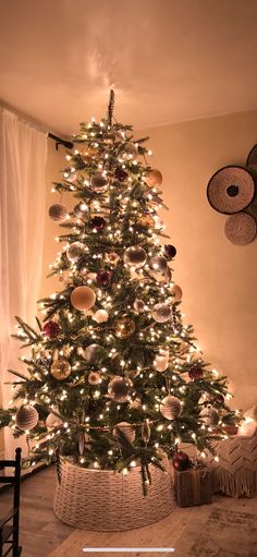 a decorated christmas tree in a living room with lights and ornaments on the top of it