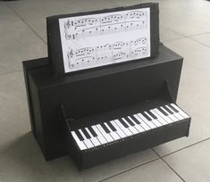 a black piano with sheet music on it's back and keyboard in the middle