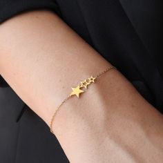 Discover our Dainty 3 Stars Solid 18K Gold Bracelet--an understated yet elegant piece crafted to elevate your style. With its minimalistic design and sleek gold finish, this bracelet exudes sophistication and charm. Adorn your wrist with this timeless accessory and make a statement of refined taste and understated luxury. Gold specifications: *Caliber: Solid 18K gold- The optimal caliber for creating high-end Jewelry pieces. At 75% purity, the metal proprieties are fully released, and Gold achie Elegant Adjustable Chain Bracelet With Star Charm, Elegant Everyday Bracelets With Star Charm, Elegant Adjustable Star-shaped Chain Bracelet, Gold Minimalist Diamond Bracelet For Party, Elegant Adjustable Charm Bracelet With Star Charm, Minimalist Bracelets With Star Charm, Modern Jewelry With Star Charm As Gift, Modern Jewelry With Star Charm For Gifts, Minimalist 14k Gold Bracelets For Party