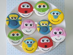 a white plate topped with lots of colorful decorated cookies on top of a blue and white table