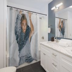 a woman taking a selfie in front of a shower curtain with the image of herself on it