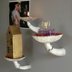 two white birds holding trays with wine bottles on them and a house shaped candle holder