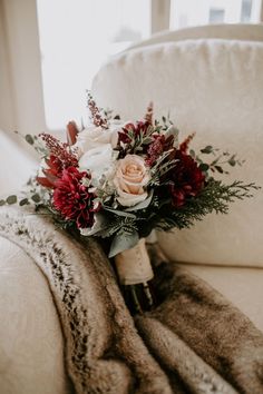 a bridal bouquet sitting on top of a couch