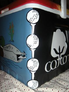 an ice chest is decorated with golf balls and trees on it's sides, along with the word cotton