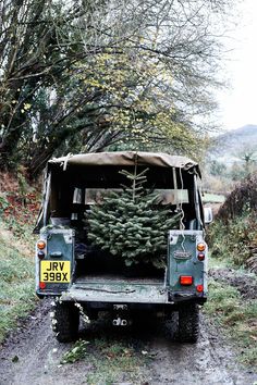 an old jeep with a christmas tree in the back