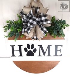 a wooden sign with a dog's paw and the word home hanging on it