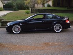 a black sports car parked in front of a house