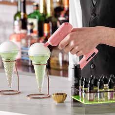 a person using an ice cream machine to make two cones with thermometers