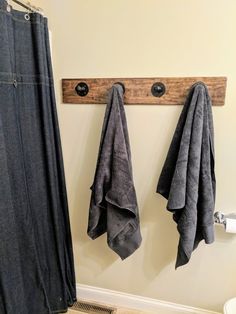 two gray towels hanging on a wooden coat rack