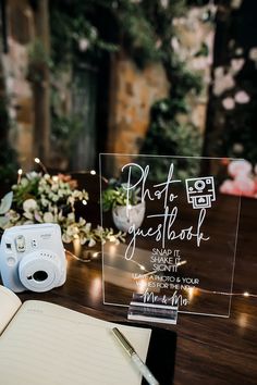 a camera and notebook on a table with flowers