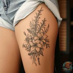 a woman's thigh with flowers and leaves tattoo on her leg, showing the back side