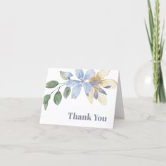 a thank card sitting on top of a table next to a vase filled with flowers