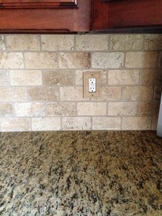 a kitchen counter top with a light switch on it's side in front of wooden cabinets