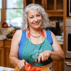 an older woman is cutting tomatoes in the kitchen